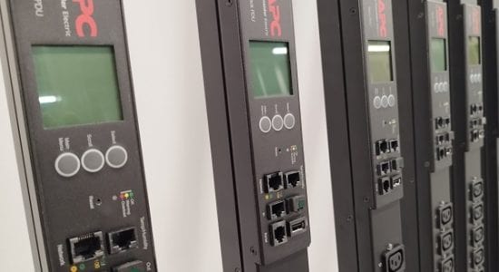 Plusieurs systèmes de redémarrage à distance PDU APC alignés côte à côte, prêts à être installés dans de nouvelles baies de serveurs, symbolisant la préparation et l'organisation en vue d'une infrastructure informatique efficace et gérable.