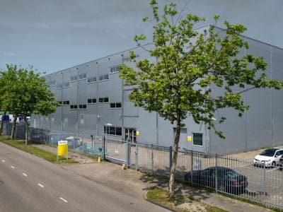 Vue extérieure du centre de données NorthC à Aalsmeer, montrant la structure moderne du bâtiment, symbole de la fiabilité et de la performance des infrastructures d'hébergement de StrictlyHosting.be.