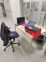 Photo de notre station de travail technique située directement dans la salle serveur du datacenter, équipée d'une caisse d'outillage, d'un ordinateur portable, et de la chaise du technicien. Cette installation permet d'effectuer des upgrades et des réparations sur place, assurant une intervention rapide et efficace pour maintenir la performance et la fiabilité de l'infrastructure serveur.