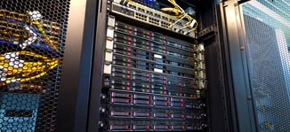 Gedetailleerde foto van een open server rack dat een reeks productieservers toont, met switches en zichtbare glasvezelverbindingen bovenaan, illustrerend de complexiteit en verfijning van de netwerkinfrastructuur nodig voor hoogwaardige webhosting.